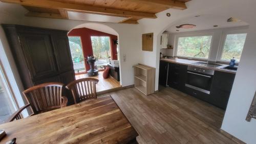 a kitchen with a wooden table and a dining room at Seychellen House in Großenkneten
