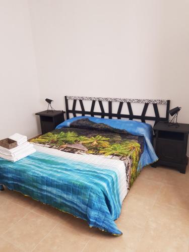 a bedroom with a bed with a blue blanket at Affittacamere Evergreen Terrace in Monzuno