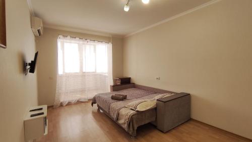 ein Schlafzimmer mit einem Bett und einem großen Fenster in der Unterkunft Олександрійський бульвар 125 CityRooms in Bila Zerkwa