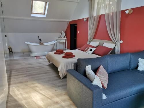 ein Schlafzimmer mit einem Sofa, einem Bett und einer Badewanne in der Unterkunft Les lits de l'Arz in Malansac
