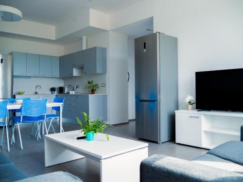 a living room with a refrigerator and a kitchen at Apartamentos Turísticos UNEATLANTICO in Santander