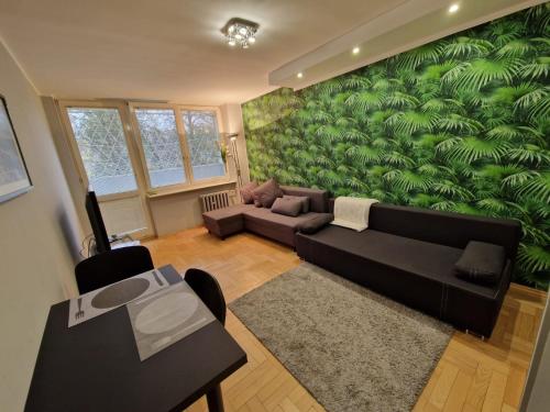 a living room with a couch and a green wall at PrzyMorze, Park i czas nad Zatoką - doskonałe miejsce na wygodny i udany urlop w Trójmieście in Gdańsk