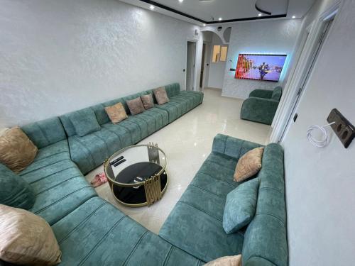 een woonkamer met een bank en een tv bij Al Hoceima Ajdir Maroc - Maison 5 chambres 10 personnes in Al Hoceïma