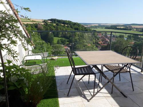 einen Tisch und Stühle auf einem Balkon mit Aussicht in der Unterkunft B&B CHEZ FOUCHS - Chambre d'hôtes in Dun-sur-Meuse