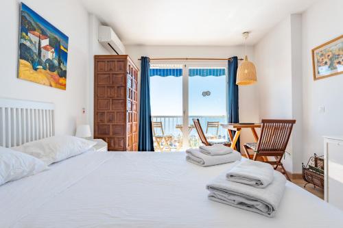 een slaapkamer met een wit bed en handdoeken bij Ventana al mar in Fuengirola