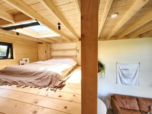 1 dormitorio en una cabaña de madera con 1 cama en NEW! Tiny House Lantliv Oostkapelle, bij de boer en Oostkapelle