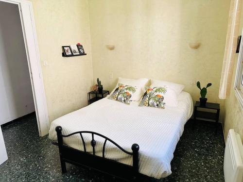 a bedroom with a bed with four pillows on it at La forge du papé in Aigues-Mortes