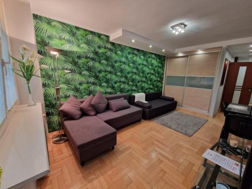 a living room with a couch and a green wall at PrzyMorze, Park i czas nad Zatoką - doskonałe miejsce na wygodny i udany urlop w Trójmieście in Gdańsk