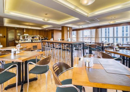 a restaurant with wooden tables and chairs and windows at Ritter Hotéis in Porto Alegre