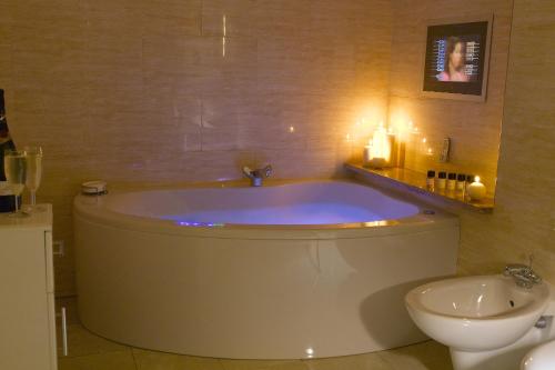 a bathroom with a tub and a toilet and a sink at The Sefton in Douglas