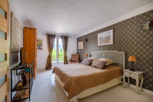 ein Schlafzimmer mit einem großen Bett in einem Zimmer in der Unterkunft Le mas des pins in Peymeinade
