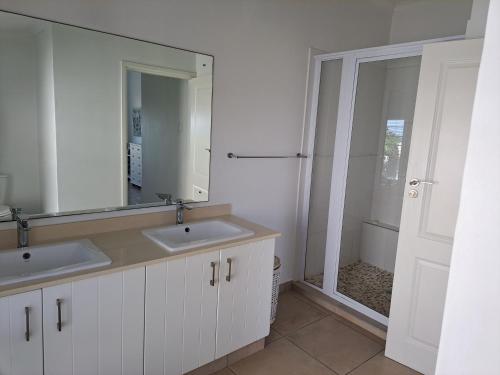 a bathroom with two sinks and a mirror at Diljaroon, 1331 Frances Avenue, Ramsgate in Ramsgate