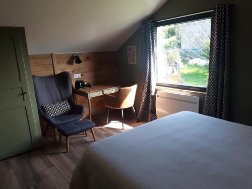 een slaapkamer met een bed, een bureau en een raam bij B&B CHEZ FOUCHS - Chambre d'hôtes in Dun-sur-Meuse