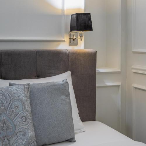 a bed with a brown headboard and a lamp at Belle Boutique in Sliema