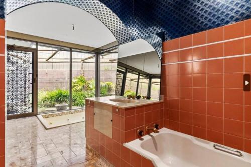 y baño con bañera, 2 lavabos y espejo. en Home Offers Stunning views, en Clapham