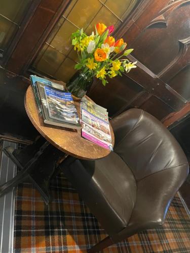 a table with magazines and a vase of flowers on it at The Dog & Partridge Country Inn in Ashbourne