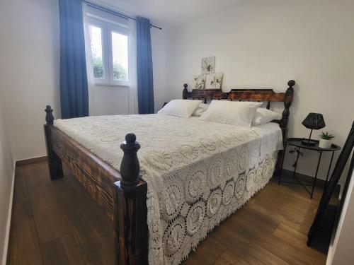 a bedroom with a large bed with a wooden frame at Blue of the sea in Krapanj