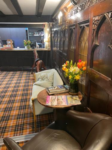 a room with a table and a couch with flowers on it at The Dog & Partridge Country Inn in Ashbourne