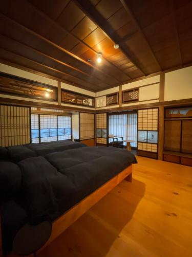 una camera con un grande letto in una stanza con finestre di HÏSOM 湯里 a Oda