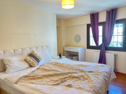 a bedroom with a large bed with purple curtains at New Studio Apartment, 1BR in Istanbul