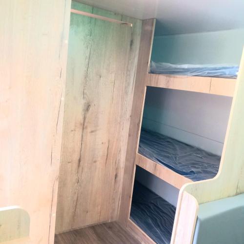 ein Etagenbett in einem winzigen Haus in der Unterkunft לנפוש על גלגלים in Kefar H̱ananya