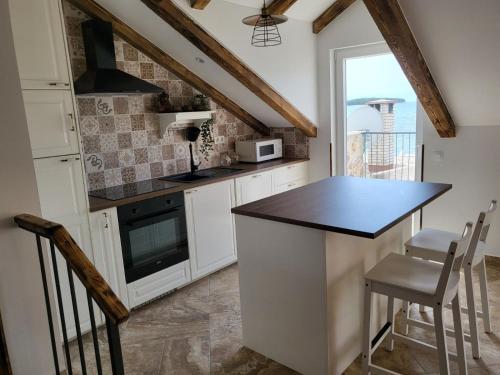 a kitchen with white cabinets and a black counter top at Blue of the sea in Krapanj