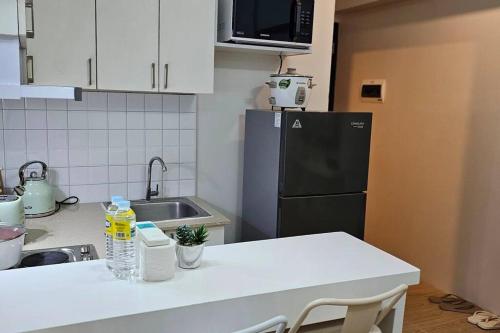 een keuken met een koelkast en een wit aanrecht bij Steff's Condo 211 At Centrio in Cagayan de Oro