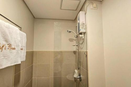 een badkamer met een douche en een glazen deur bij Steff's Condo 211 At Centrio in Cagayan de Oro