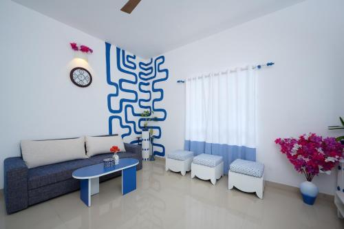 a living room with a couch and a table and chairs at Seclude by the Lake, Alleppey in Alleppey