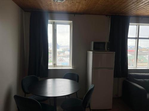 a kitchen with a table and chairs and a window at Húsavík Apartments in Húsavík