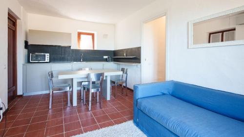 sala de estar con sofá azul y mesa en Welcomely - Petra - Residence Country di Porto Rotondo, en Porto Rotondo