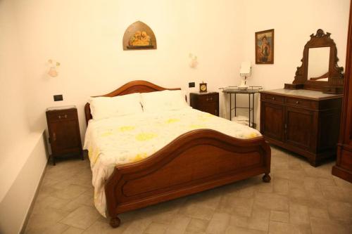 a bedroom with a large wooden bed and a dresser at L'antico Frantoio dei nonni in Sestri Levante
