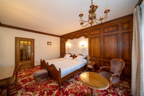 sypialnia z łóżkiem, stołem i krzesłami w obiekcie Hotel Munsch Restaurant & Wellness, Colmar Nord - Haut-Koenigsbourg w mieście Saint-Hippolyte