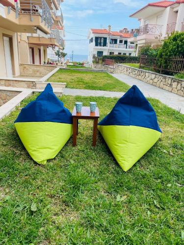 two tents sitting on the grass next to a table at DARIVA apartment Nea Skioni in Nea Skioni