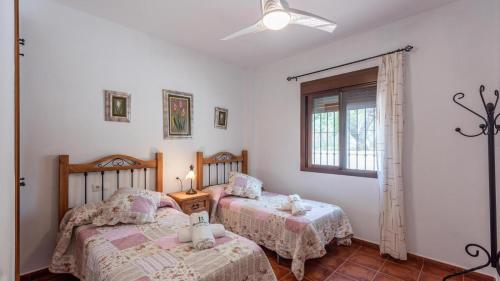 - une chambre avec 2 lits et une fenêtre dans l'établissement Cortijo Sylvestris Periana by Ruralidays, à Periana