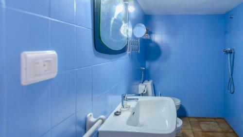a blue bathroom with a sink and a toilet at La Guitarra Andaluza Loja by Ruralidays in Loja