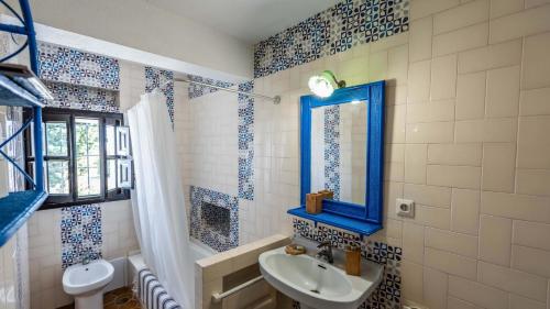 ein Bad mit einem Waschbecken, einem WC und einem Fenster in der Unterkunft Viña Meneses La Puebla de Cazalla by Ruralidays in Sevilla