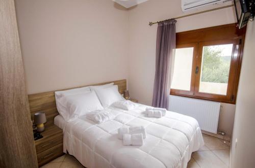 a bedroom with a white bed and a window at Horio House in Límni