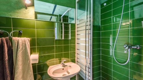 a green tiled bathroom with a sink and a shower at El Pencal Azul Rincón de la Victoria by Ruralidays in Rincón de la Victoria