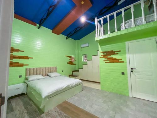 una camera da letto con pareti verdi e un letto e scale di Miramida Hotel a Zaqatala