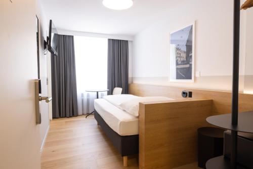 a hotel room with a bed and a table at Fred Hotel Zürich Hauptbahnhof in Zürich