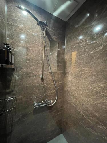bagno con doccia e parete in pietra di HÏSOM 湯里 a Oda
