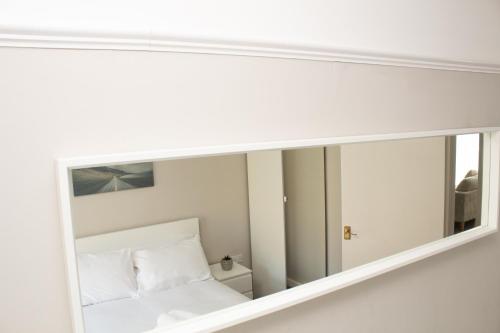 a mirror on the wall of a bedroom at Cosy 3Bed Bungalow in West Kirby, Free Parking in Frankby