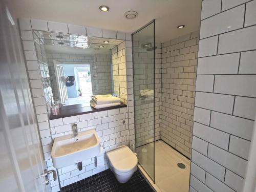a bathroom with a sink and a toilet and a shower at The Townhouse in Falmouth