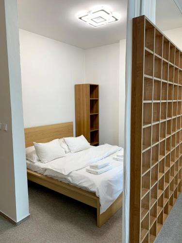 a bedroom with a bed in a room with shelves at Holiday home Prague in Prague