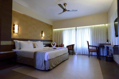 pokój hotelowy z dużym łóżkiem i biurkiem w obiekcie La Grace Resort w mieście Benaulim