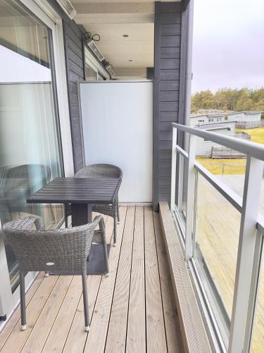 a patio with a table and chairs on a balcony at Kostergården in Sydkoster