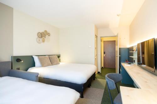 um quarto de hotel com duas camas e uma secretária em Green Park Hotel Brugge em Bruges