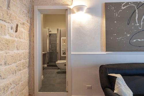 a room with a bathroom with a toilet and a couch at San Pietro Apartment in Bari