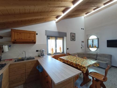 eine Küche und ein Wohnzimmer mit einem Sofa und einem Tisch in der Unterkunft Casa Le Fornaci in Ispra